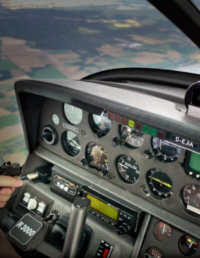 Das Cockpit eines Flugzeugs, im Hintergrund eine verschwommene Landschaft